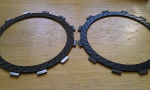 On the left, a new friction plate. On the right, the old, worn friction plate.